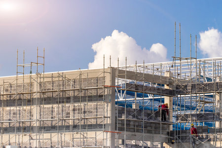 Man working on construction site with scaffold and building with sky background,scaffolding for construction factoryの写真素材