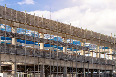 Scaffolding pipe clamp and parts,construction site with scaffold and building strength to scaffold clamps in used on construction site with sunset background,scaffolding for construction factoryの写真素材