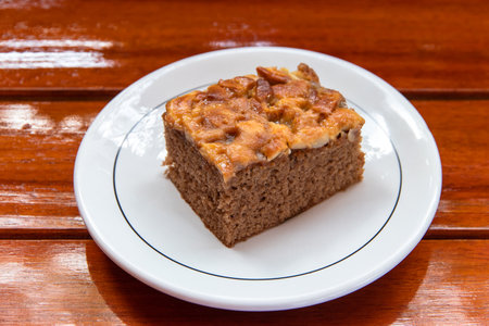 Chocolate cake on a white plate look appetizing placed on a wooden tableの写真素材