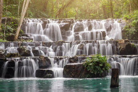 Small waterfall with water splashing and tumbling over the rocks in the forest on a bright sunny,Sam...