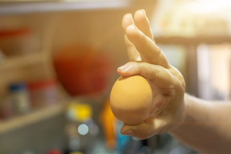 Chicken eggs in a woman's hand. Housewife is preparing eggs for cooking in the kitchen.の写真素材