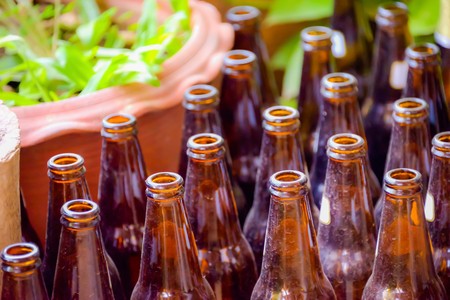 Empty glass bottle was put aside without caring who noticed the dust captured by the surface of it.の写真素材