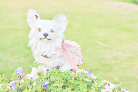 A stucco dog was placed beside the tree.の写真素材