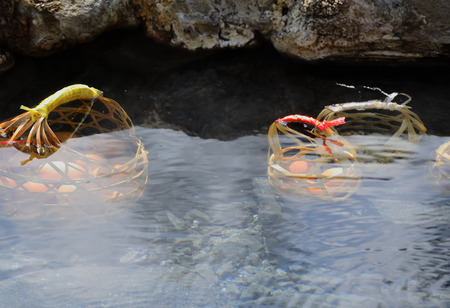 Put the eggs in the basket, then soak them in the hot springs to be cooked and eaten.の写真素材