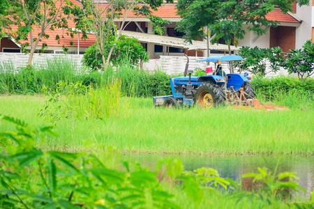 The gardener uses a tractor to mow the lawn.の写真素材