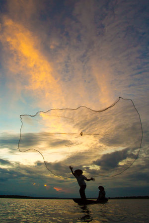 Fishermen in action when fishing in the lake.の写真素材