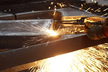 Industrial worker welding in steel factory