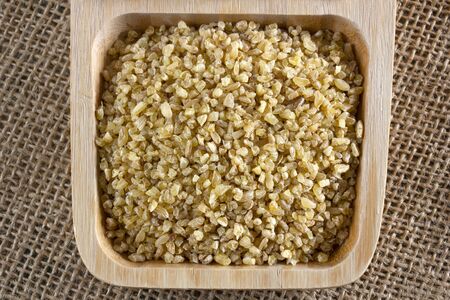 raw wheat grains in wooden plate
