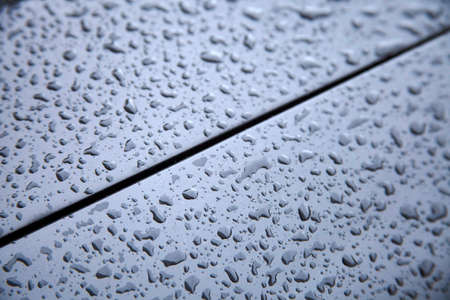 Water drops collect on top of metallic car surfaceの写真素材