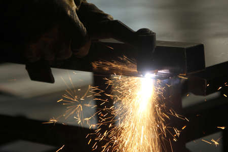 Steel cutter grinder and sparks in workshop.