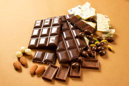 White and milk chocolates. Almond, pistachio, hazelnut .. background, texture ..