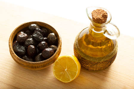 A plate of olives and a lemon slice. Organic olive oil.の写真素材