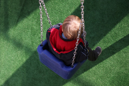 Boy having fun on the swing. Preschool.