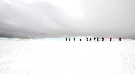 Group of mountaineers walking trough the mountains covered with snow.の写真素材
