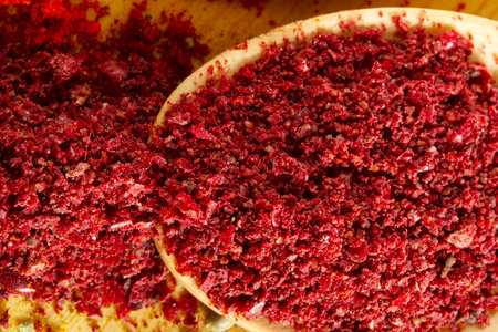 Red pepper flakes in a wooden spoonの写真素材