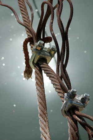 Wire rope clamps and rusty steel ropes.