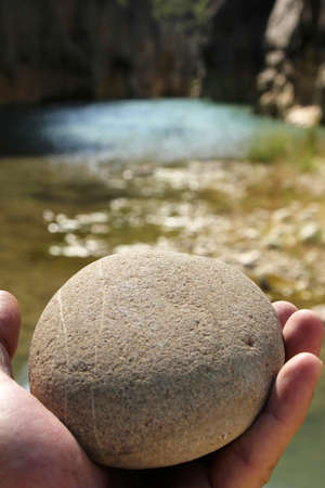 A hand holding a stone. Man and nature.の写真素材