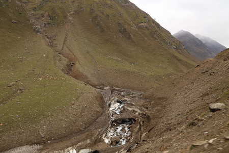 The mountain river flows between the rocks in the mountainsの写真素材