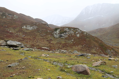 Small Rocks On Big Mountain Under Cloudy Skyの写真素材