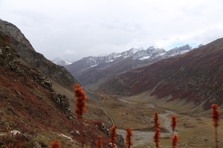 Mountains in autumn with brown and reddish grass under cloudy skyの写真素材