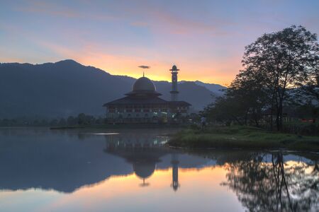 Beautiful and dramatic scenery of sunrise at Mosque with reflection