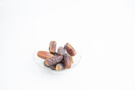Close up, dates on glass tray isolated on white background, selective focus, Islam religion fasting on ramadan mubarak celebration concept.の写真素材