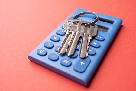 Keys on mini blue calculator isolated, home, security, bank loan, financial concept, future family planning, close up selective focus, copy space.の写真素材