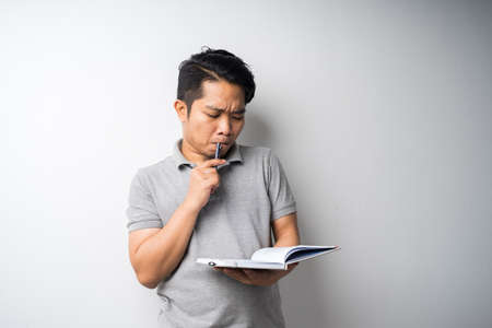 Portrait of Asian man holding book with face expression