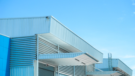 Factory warehouse and industrial concept - Wall and roof of Factory or warehouse building in industrial estate with blue sky and copyspaceのeditorial素材