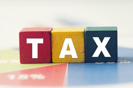 Tax Concept with colorful wooden block tax word on pie chartの写真素材