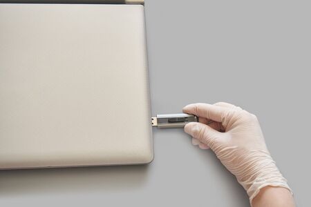 Hand in white glove insert usb flash disc at lattop. Anti virus protect concept. Medical home...