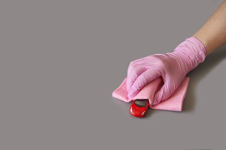 Hand in glove holding toy car. Safety anti virus conceptの写真素材