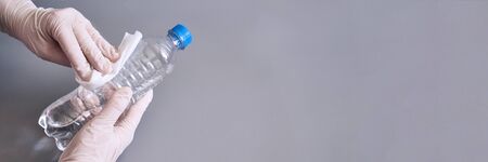 Hand in white glove holding bottle of sanitizer gel.の写真素材