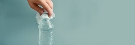 Hand in white glove holding bottle of waterの写真素材