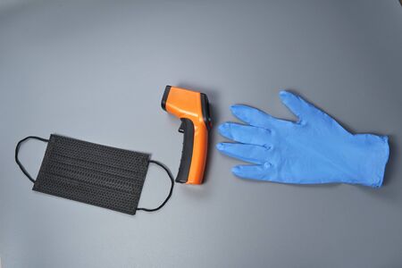 blue glove ir thermometer and black surgical mask. copyspaceの写真素材