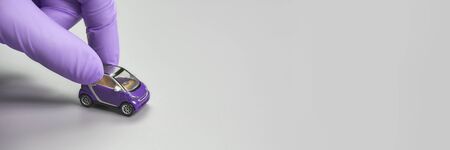 Hand in glove defend toy car. Safety anti virus conceptの写真素材