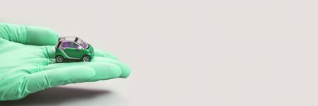 Hand in glove hold toy car. Safety anti virus conceptの写真素材