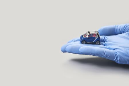 Hand in glove defend toy car. Safety insurance conceptの写真素材