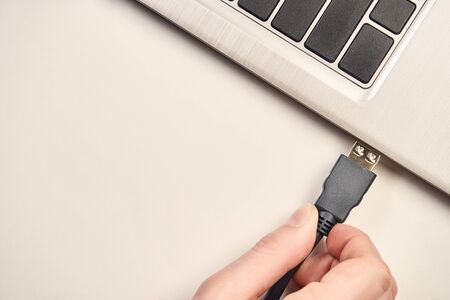 Hand holding video cable connector for plug to laptopの写真素材