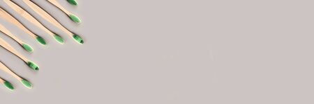 Wooden eco toothbrush. Natural bamboo dentist care. twenty first century zero waste concept. Bathroom organic reusable ecological items. Grey background. Top view. Copyspase banner.の写真素材