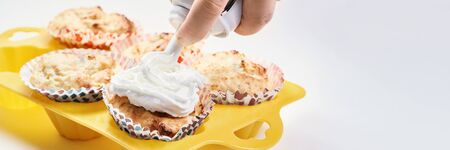 beautiful cupcakes topped with whipped cream. The concept of cooking baking home. Forms for homemade delicious buns. Trying a new baking recipe. tasty lesson at school. party for children and adultsの写真素材