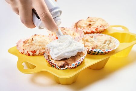 beautiful cupcakes topped with whipped cream. The concept of cooking baking home. Forms for homemade delicious buns. Trying a new baking recipe. tasty lesson at school. party for children and adultsの写真素材