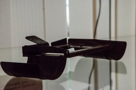 Close-up of a pair of black glasses on a glass tableの写真素材