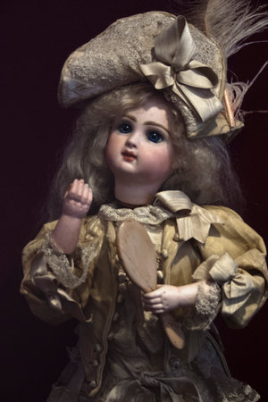 Vintage toy girl in a beautiful dress on a dark background.の写真素材