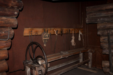 Old wooden mill with ropes and wheel in the interior of the house