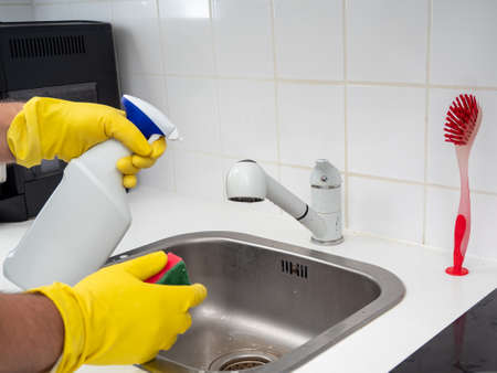 Cleans the kitchen faucet. Kitchen cleaning. Dirty electric stove.の写真素材