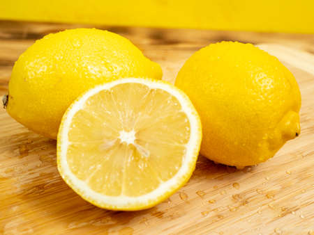 Sliced fruits. Ripe lemon on a wooden board. Fresh lemons on a wooden background.の写真素材