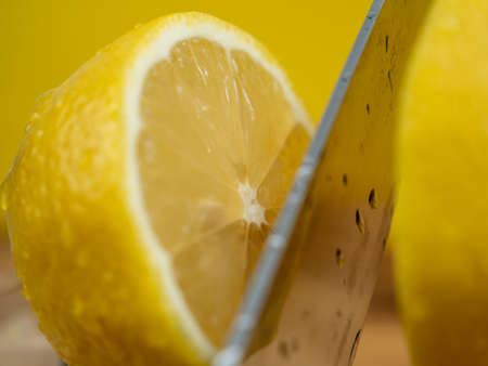 Sliced lemons with a knife. Ripe lemon on a wooden board. Fresh lemons on a wooden background.