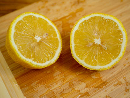 Sliced fruits. Ripe lemon on a wooden board. Fresh lemons on a wooden background.の写真素材