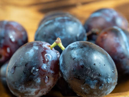 Fresh juicy plums. Plums on a wooden background. close upの写真素材